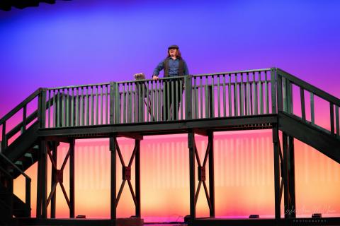 Newsies stage set with multi-level wooden bridge and railings.