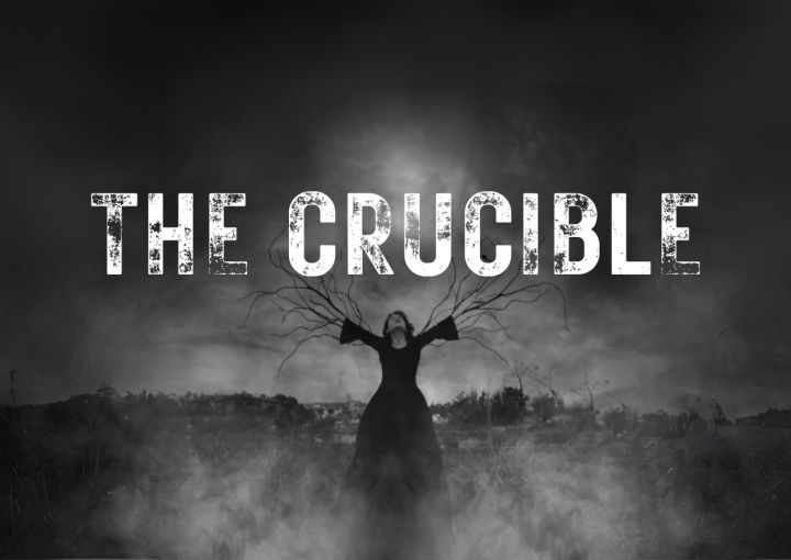 Black and white image of a girl on a stake with branches growing out of her arms. Smoke and dark lighting with The Crucible in rough looking letters